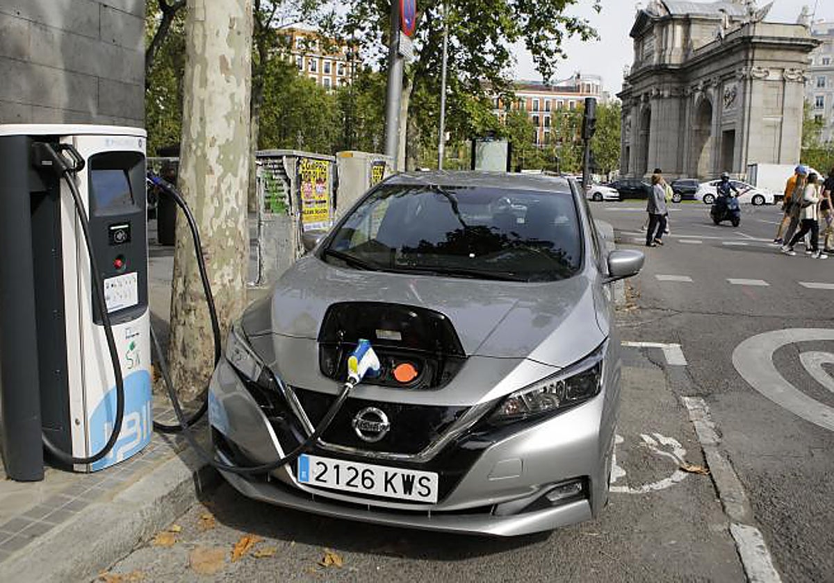 Un vehículo eléctrico carga su batería junto a la Puerta de Alcalá