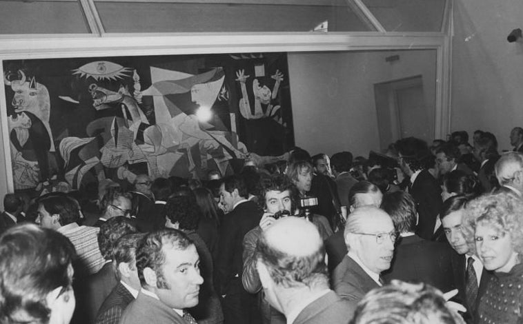 Imagen principal - Arriba, presentación del Guernica en el Casón del Retiro; entre la multitud, el alcalde Enrique Tierno y la duquesa de Alba. Abajo, los dos camiones con su escolta por la carretera de Barcelona (izq.), y pasando junto a la Puerta de Alcalá