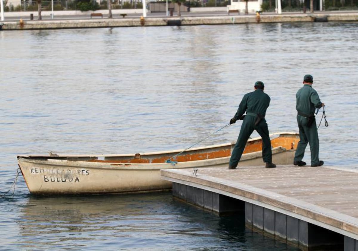 Imagen de archivo de dos agentes de la Guardia Civil con una patera en el puerto de Alicante