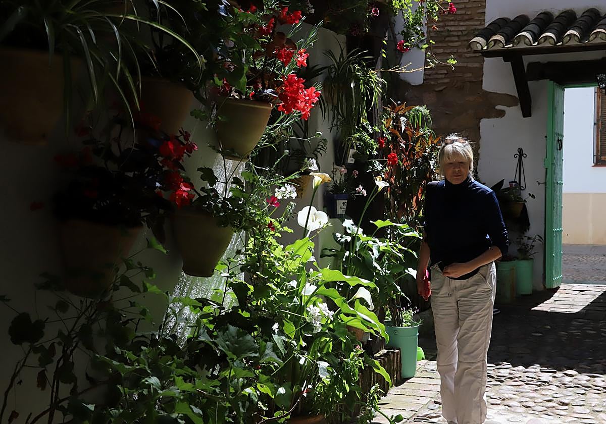 Una mujer frente a una pared de macetas en el patio conocido como de las Costureras, en San Basilio