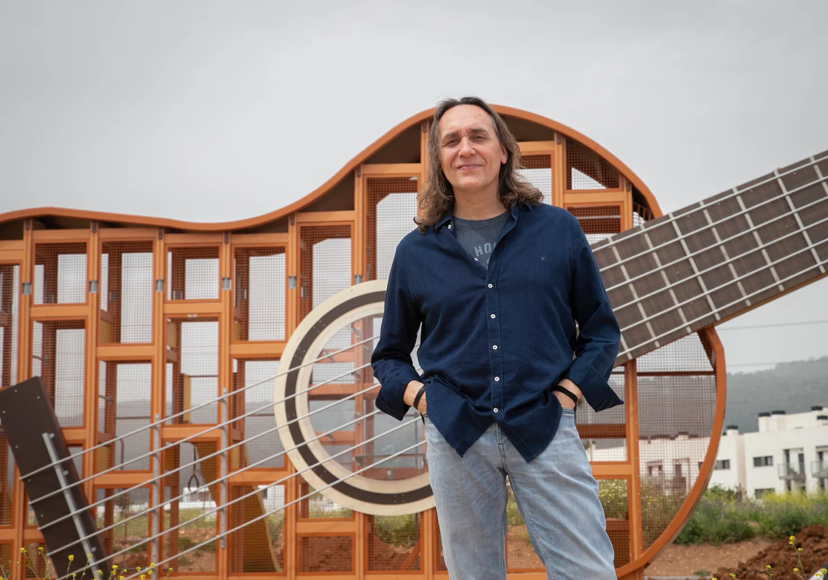 Vicente Amigo posa delante de una guitarra gigante como juego infantil en un parque de Córdoba