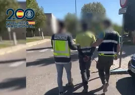 Dos policías trasladan al detenido, aún con el mono de la obra