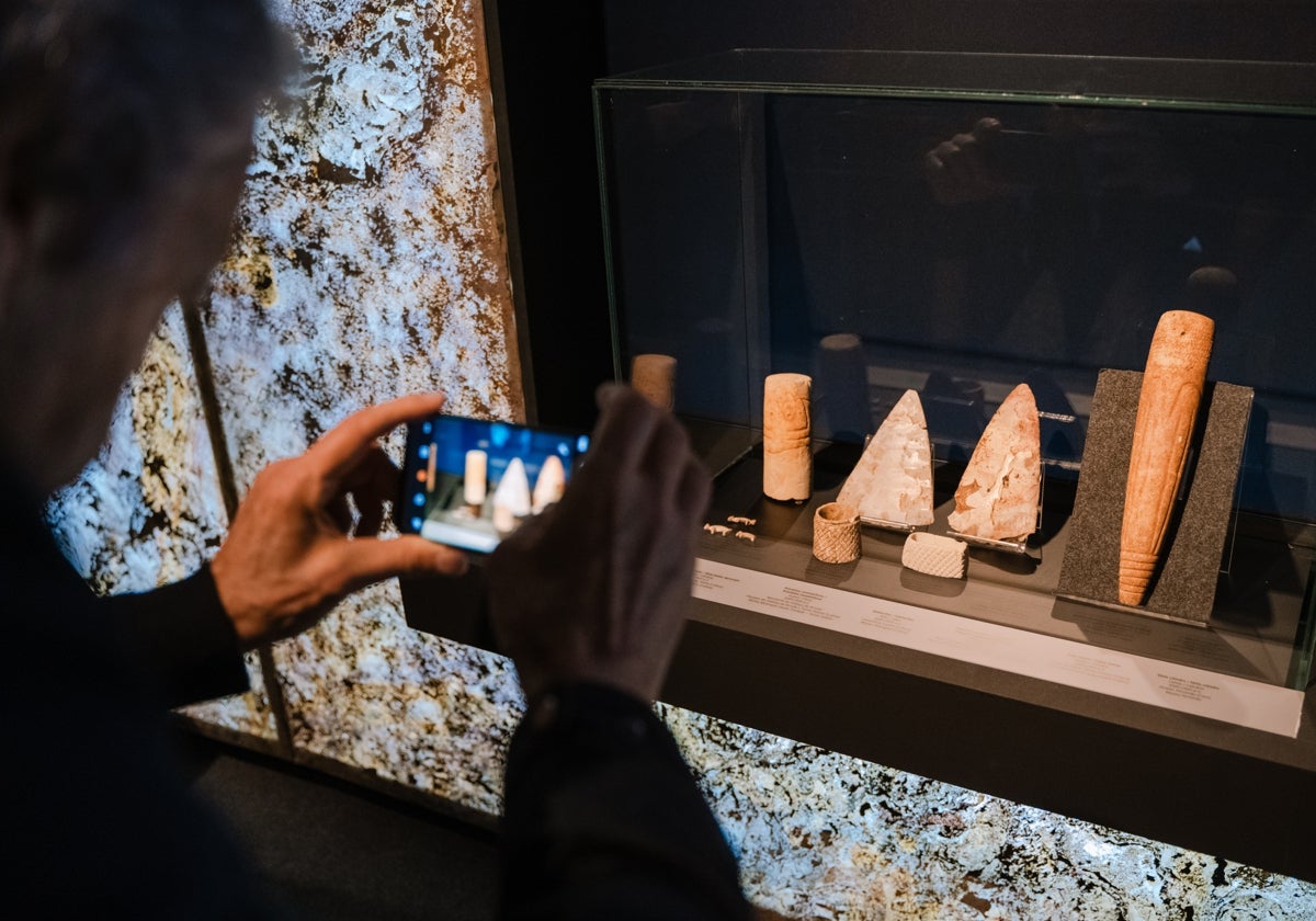 Un visitante fotografía algunas piezas de la exposición 'ïdolos' del Marq en el Museo de Huelva.