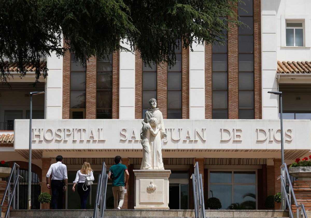 Tres personas se dirigen a la entrada principal del centro sanitario