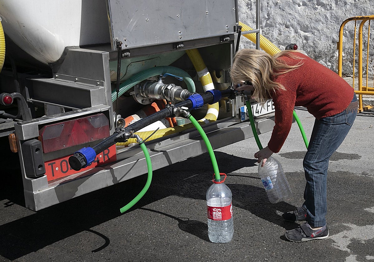 Una mujer llena sus garrafas desde un camión cisterna en Villanueva de Córdoba