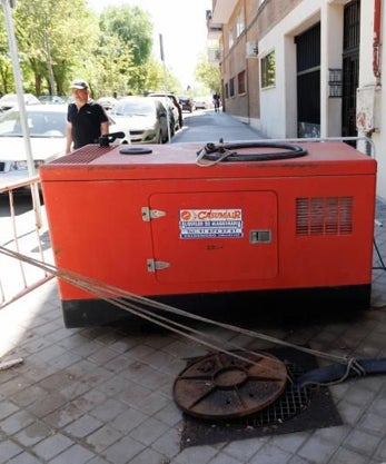 Imagen secundaria 2 - Sobre estas líneas y a la izquierda, los obreros trabajando esta semana para tapar el socavón, que alcanza los 4 metros de diámetro. Abajo, una bomba que extrae el agua para vertirla en la alcantarilla