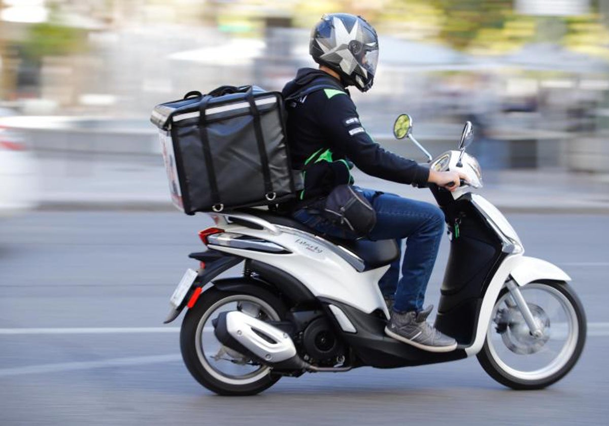 Imagen de archivo de un repartidor en moto a domicilio