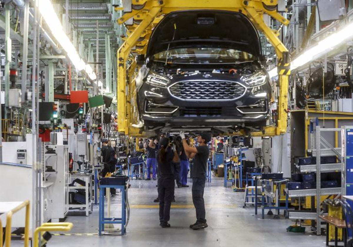 Dos trabajadores con un vehículo de la fábrica de Ford en Almussafes