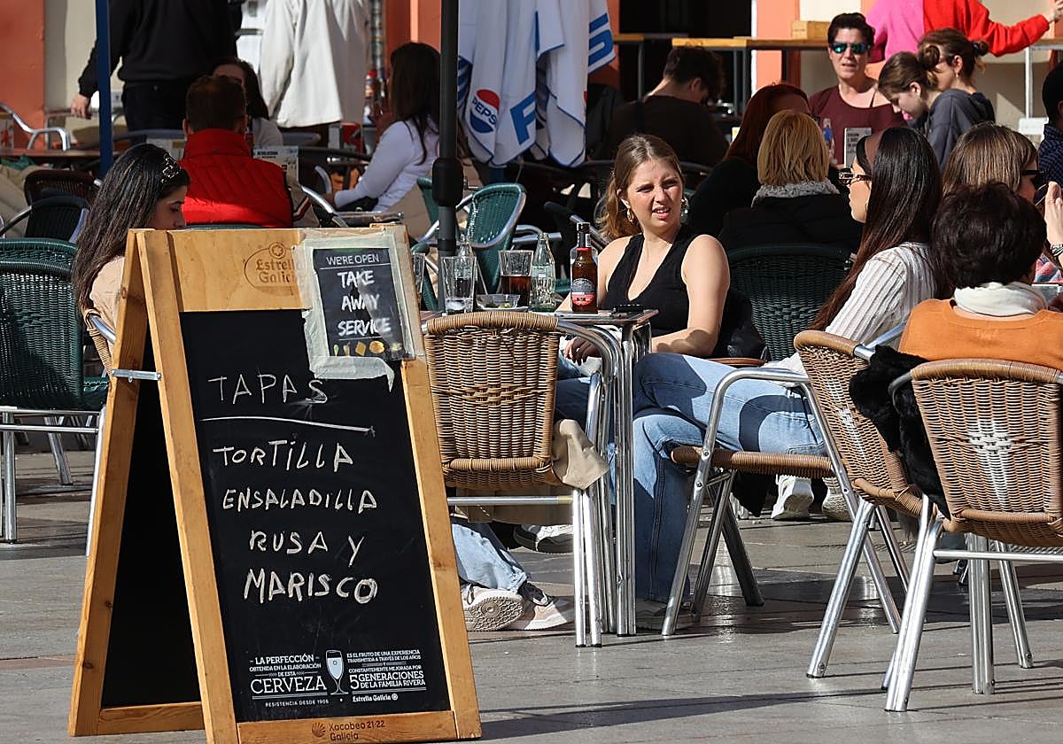 Dos jóvenes, en una terraza de la Corredera