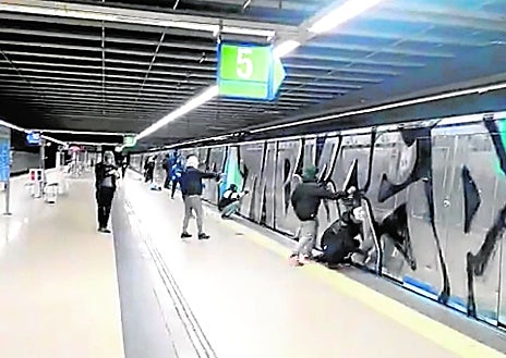 Imagen secundaria 1 - Los grafiteros volvieron a hacer de las suyas esta semana en Metro y Cercanías. Parte de las pintadas que realizaron en un tren de Renfe; un grupos de vándalos 'decorando' un convoy de Metro; y otro joven retratrado en plena acción por un pasajero