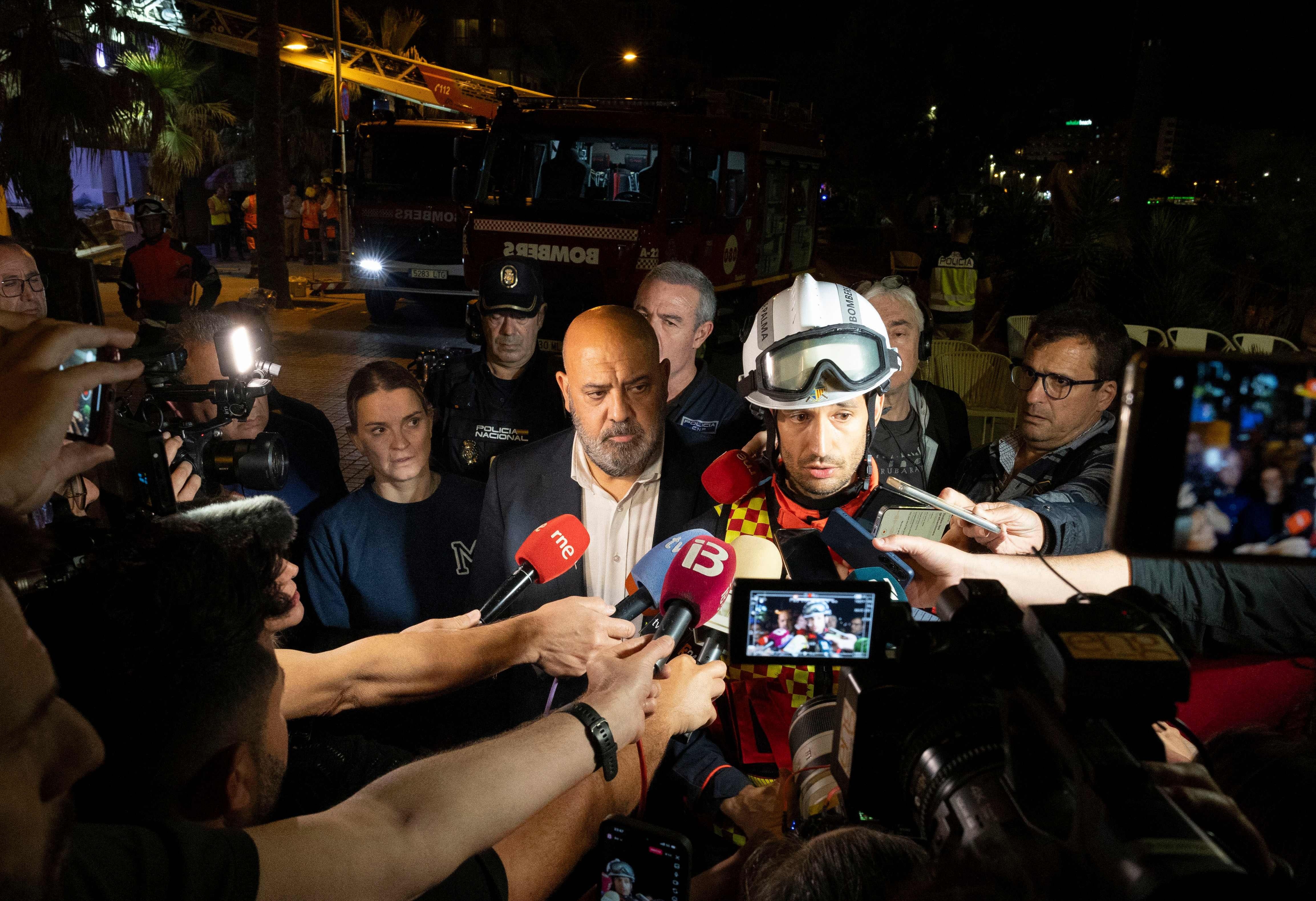 El jefe de bomberos, Eder García, flanqueado por el alcalde de Palma, Jaime Martínez y la presidenta del gobierno balear, Margalida Phroens, habla con los medios después del colapso del restaurante