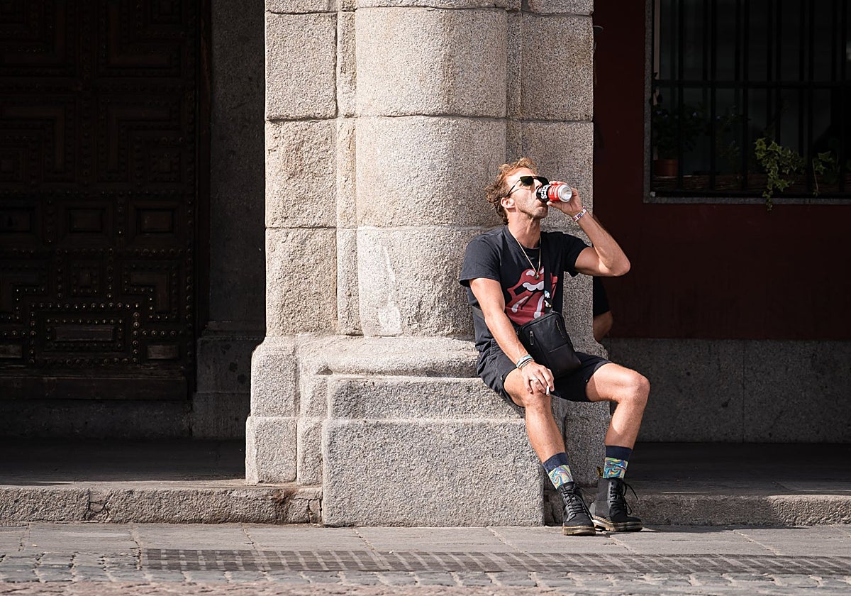 Un hombre se hidrata en plena ola de calor en Madrid