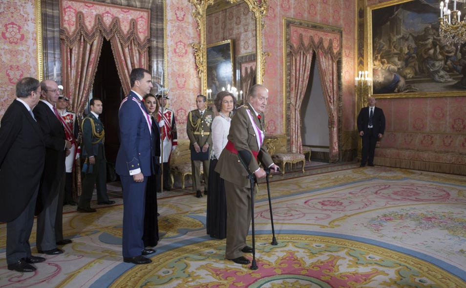 Imagen principal - En su discurso en la Pascua militar de 2014, Don Juan Carlos trastabilló en distintos momentos. Se le veía físicamente cansado. En la imagen, junto a la Reina Sofía y los entonces Príncipes de Asturias el 5 de enero de 2014 (arriba). El Rey Juan Carlos saluda a la prensa tras recibir el alta y salir del hospital tras pasar ocho días hospitalizado en agosto de 2019 (a la izquierda). El fallecimiento de Adolfo Suárez, en marzo de 2014, fue otro elemento de desgaste. La generación que le acompañó en los años de la Transición política, casi cuarenta años atrás, estaba desapareciendo. La imagen de la derecha, tomada por Adolfo Suárez Illana, fue el último encuentro de ambos 