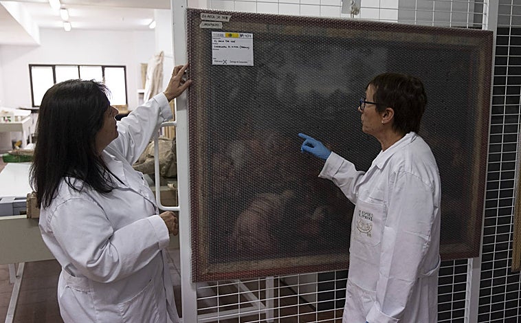 Imagen principal - Obra embalada espera a ser trasladada a las sedes de la exposición. A la derecha, detalle de una intervención