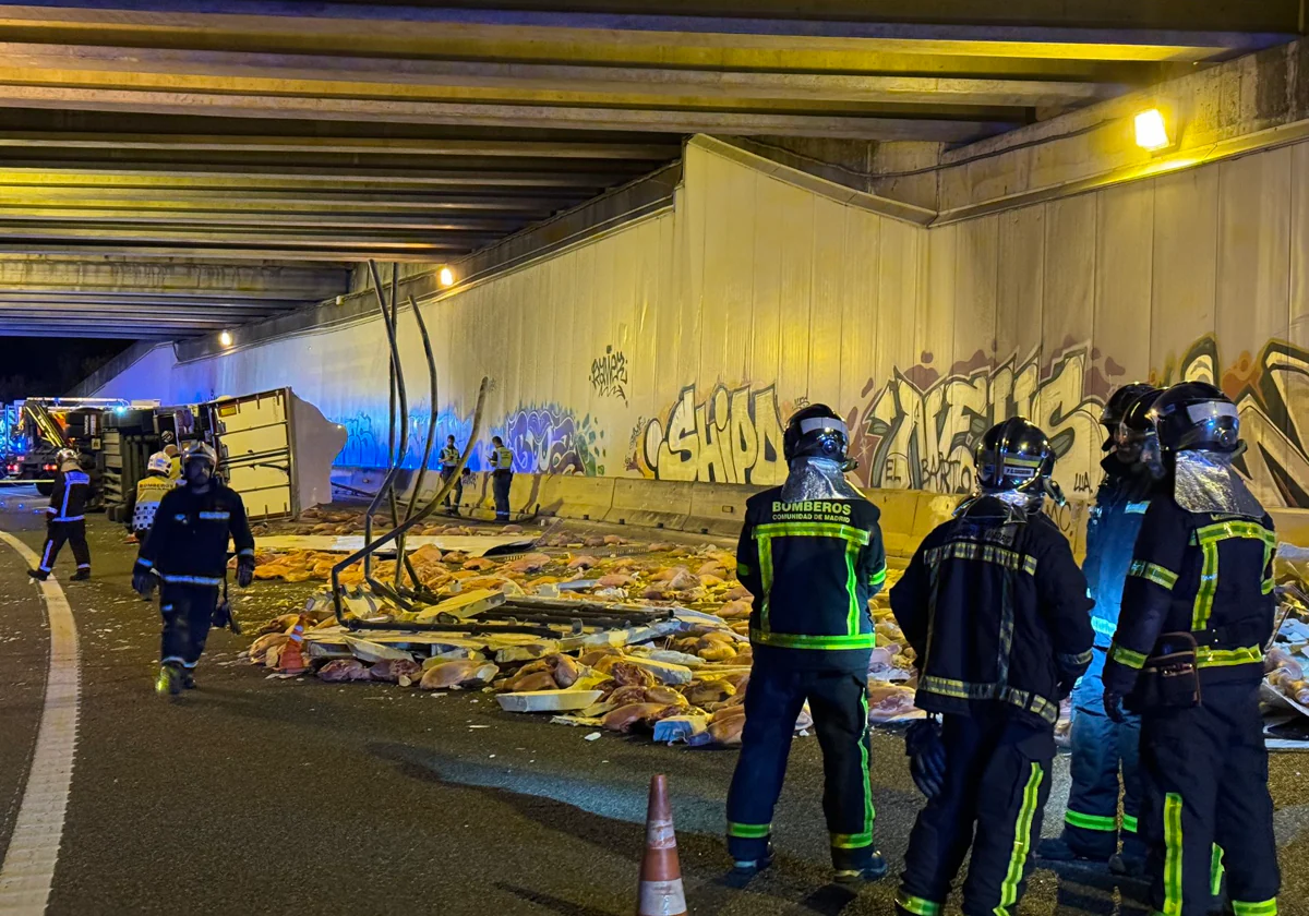 Los bomberos, en el lugar del accidente, con los jamones en la calzada