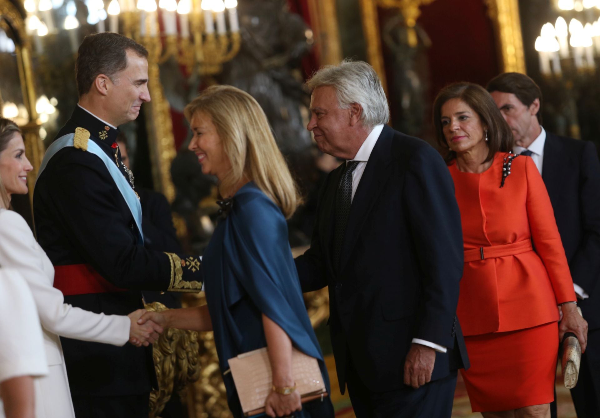 Hasta el Salón del Trono acudieron también los expresidentes del Gobierno. En esta imagen se observa a Felipe González estrechando la mano a Don Felipe. Acudió a la recepción con su mujer Mar García Vaquero, quien se encuentra en la imagen saludando a Doña Letizia. Tras el matrimonio aparecen José María Aznar y la entonces alcaldesa de Madrid, Ana Botella.