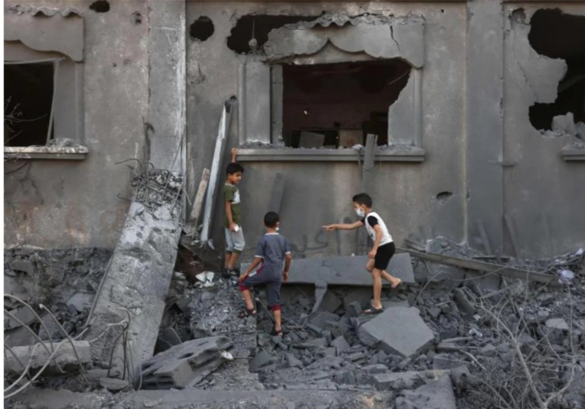 Niños palestinos, entre las ruinas de una vivienda destruida en Gaza