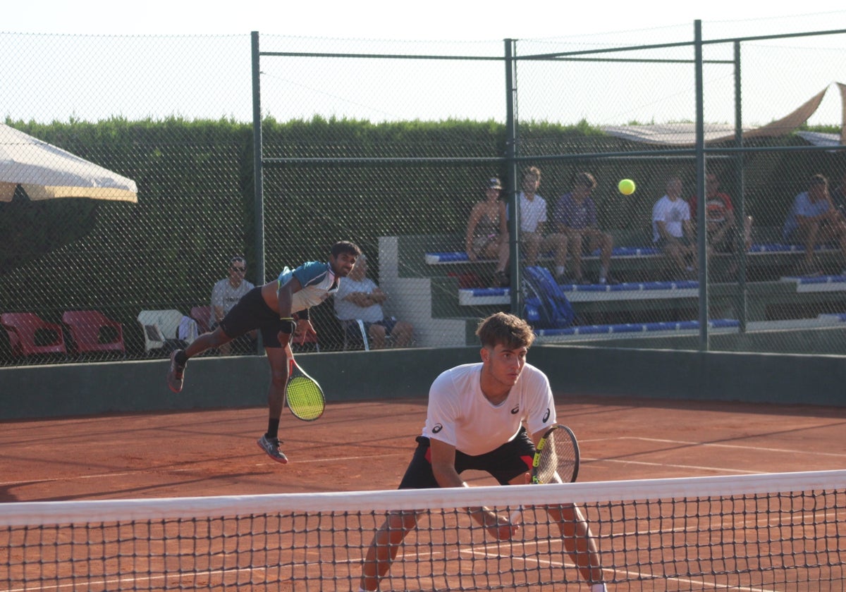 Un tenis saca en la primera ronda de un partido de dobles en el Aeroclub