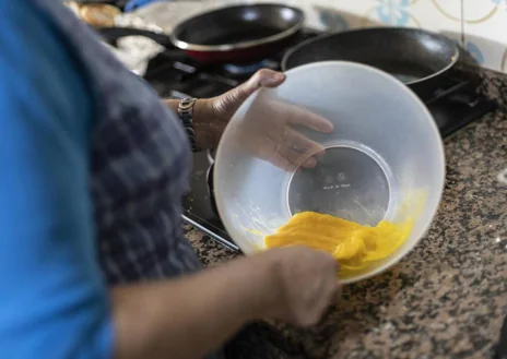 Imagen secundaria 1 - Dos hombres beben vino en una mesa del furancho O Alboio, de Marín (Pontevedra). En las imágenes inferiores, Peregrina bate huevos y Amancio pela patadas para una tortilla, en otro furacho, que lleva su nombre, de la misma localidad