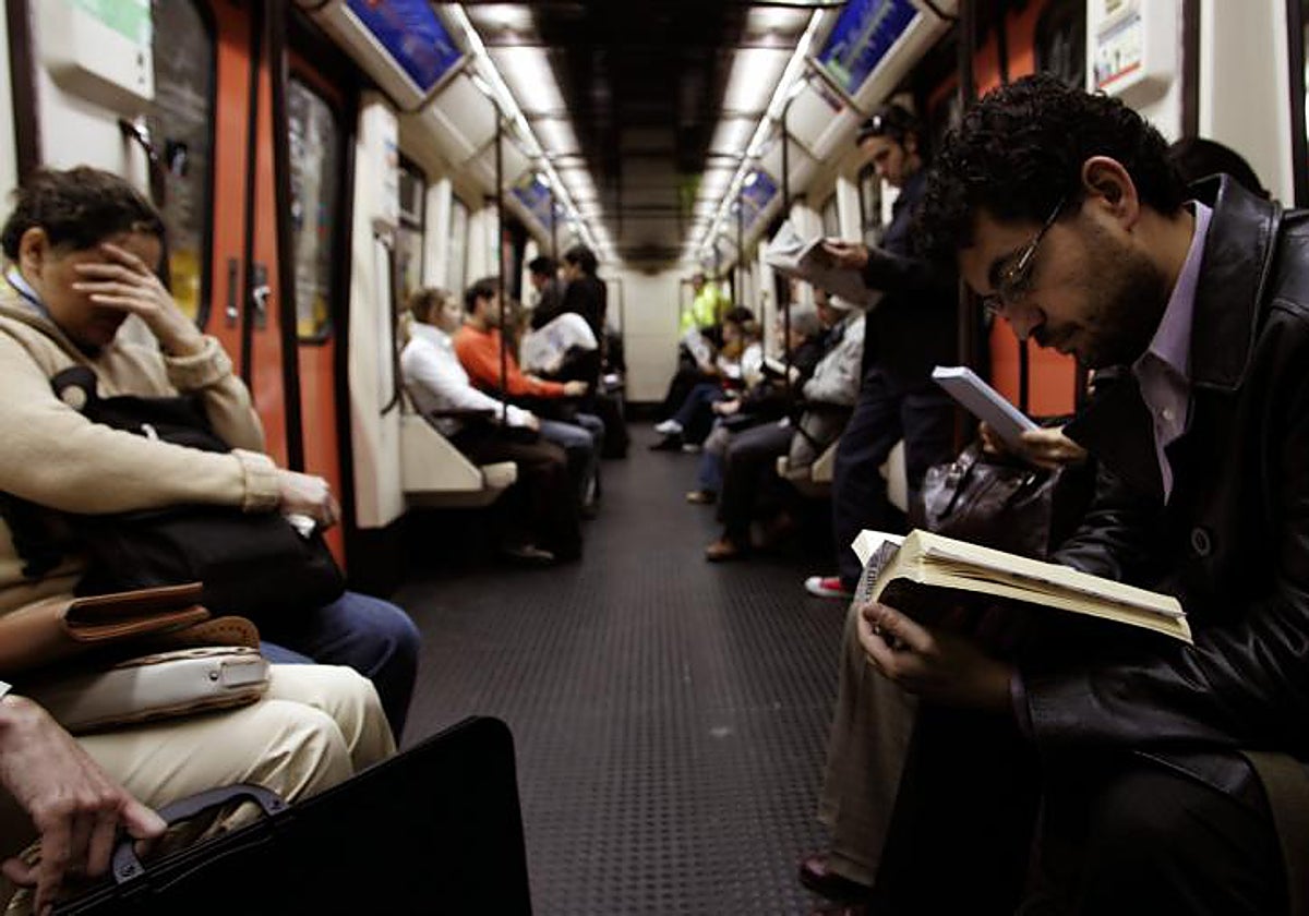 Varios usuarios del metro leen en el vagón
