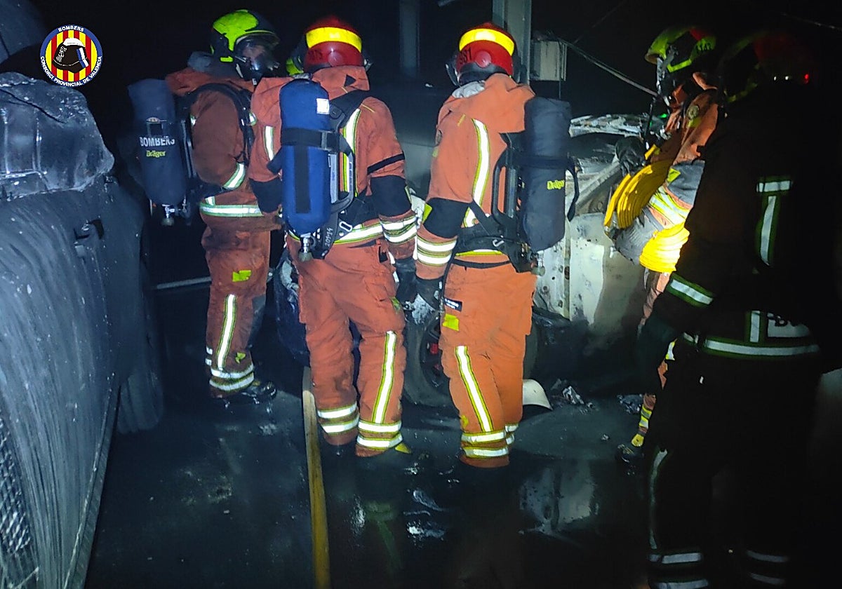 Imagen de bomberos trabajando en el incendio de un concesionario de coches en Valencia