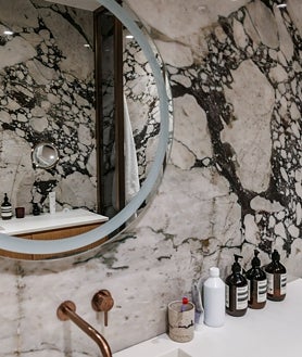 Imagen secundaria 2 - Este piso reformado de Justicia tiene doce balcones en pleno centro de Madrid y materiales exclusivos, como baldosas de mármol de Calacatta Viola en el baño. 