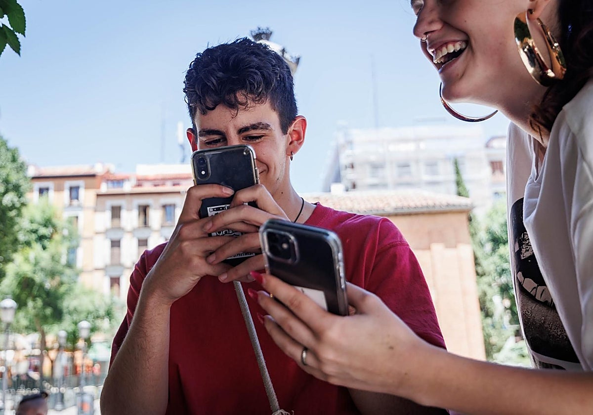 Jóvenes atentos a las pantallas de sus móviles
