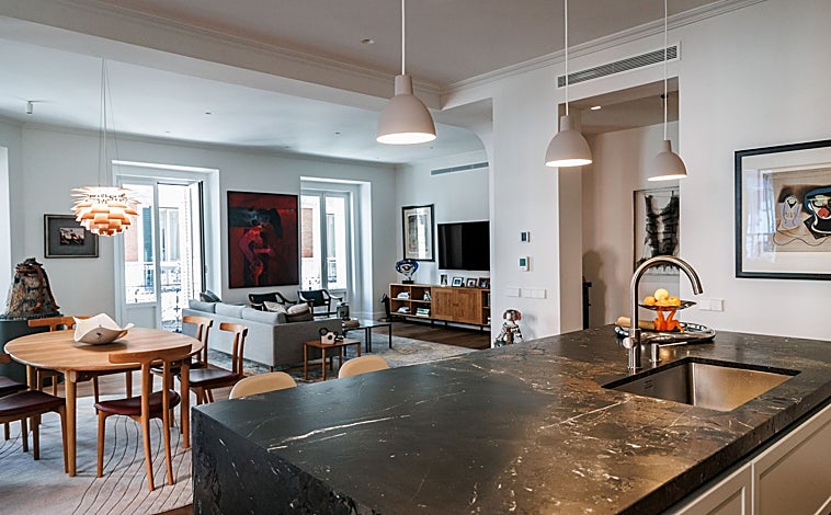 Imagen principal - Este piso reformado de Justicia tiene doce balcones en pleno centro de Madrid y materiales exclusivos, como baldosas de mármol de Calacatta Viola en el baño. 