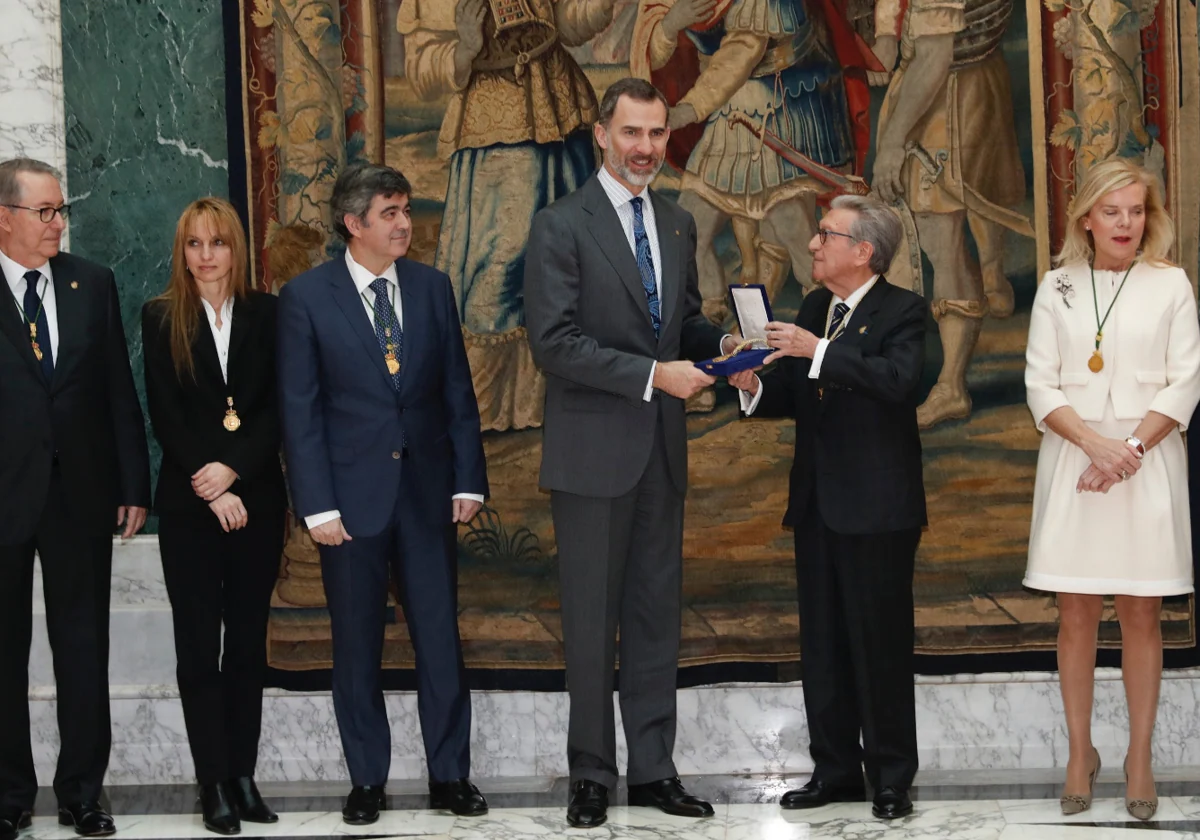 El Rey recibe la medalla de honor de la Real Academia de Ciencias Económicas y Financieras (RACEF) de manos de su presidente, Jaime Gil Aluja, en presencia de otros académicos en 2017