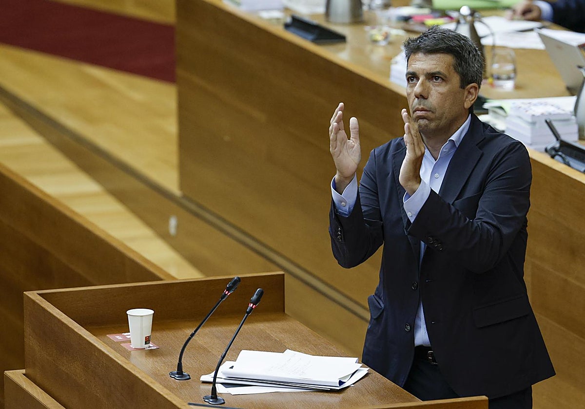 El presidente de la Generalitat, Carlos Mazón, aplaude durante su intervención en la sesión de control de las Cortes Valencianas