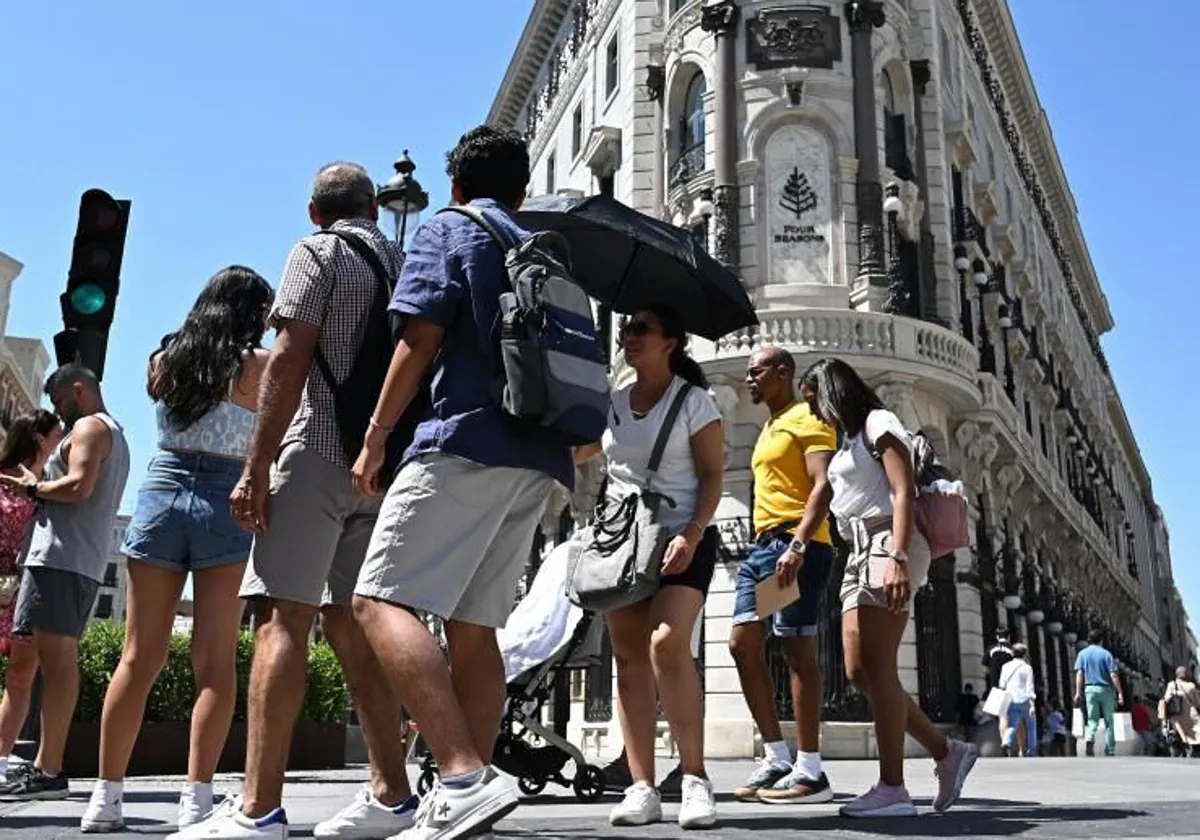 Gente paseando bajo el sol de Madrid