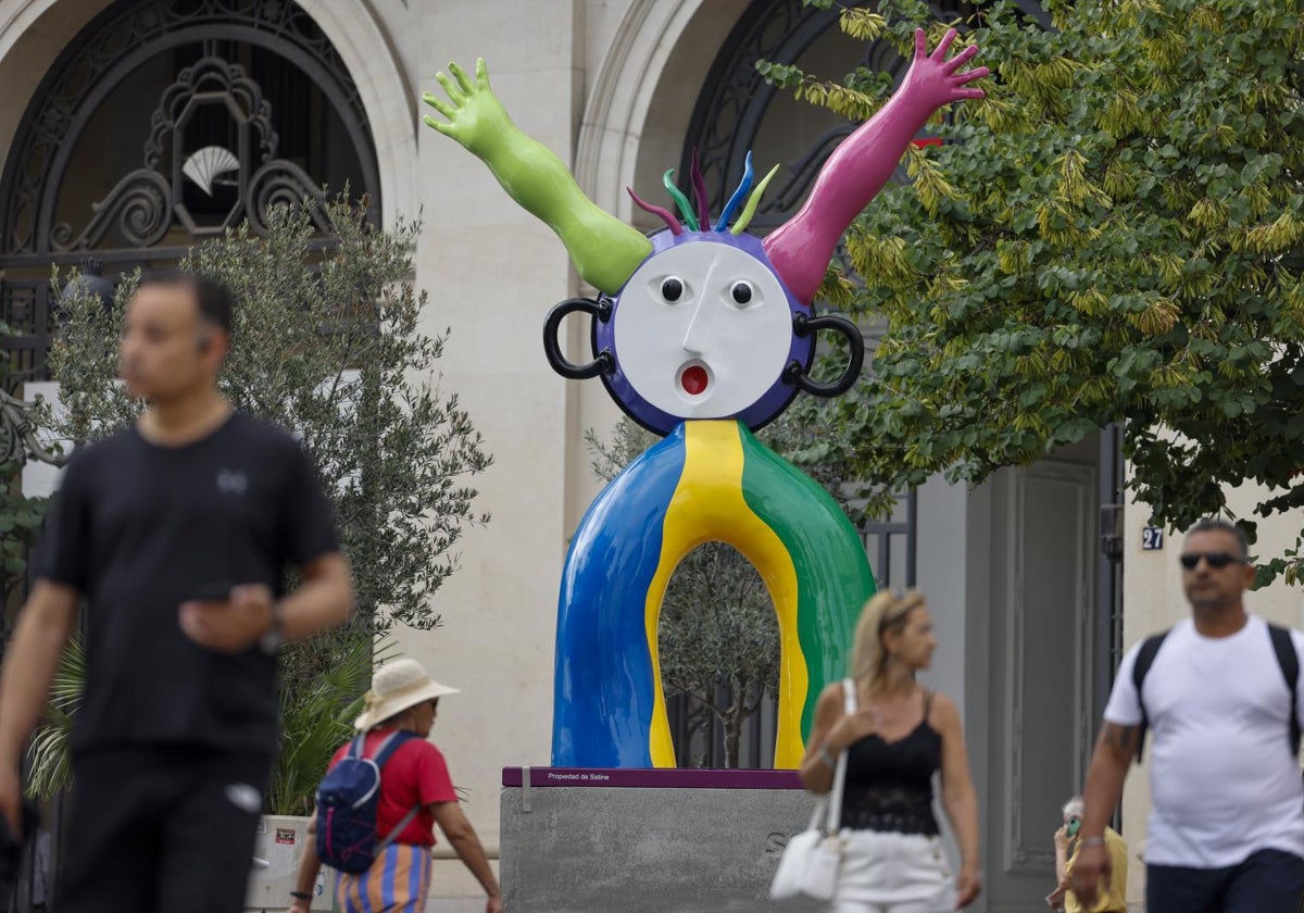 Varias personas transitan junto a la escultura 'La Paella', de Ripollés, en Valencia