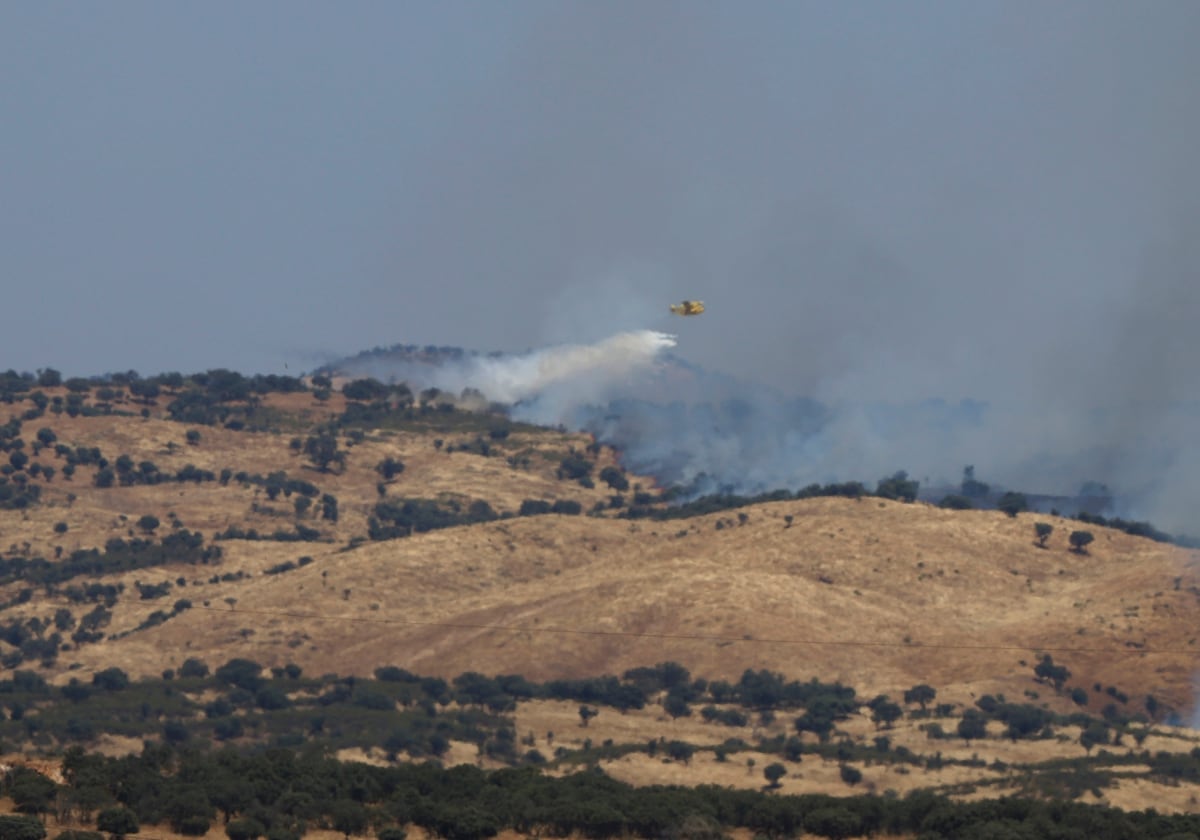 Un avión descarga agua sobre una de las zonas afectadas por el incendio de Obejo