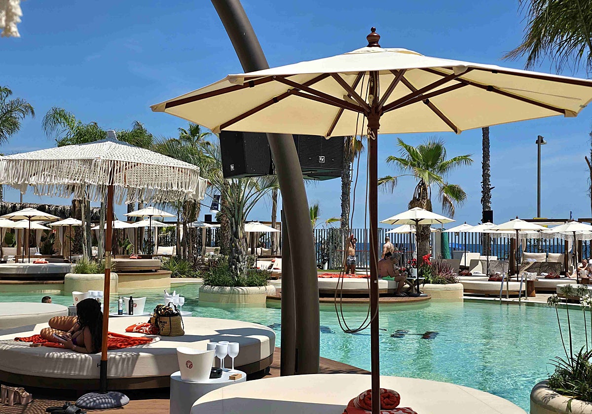 Aspecto de la piscina del Bastian Beach Club, rodeada de camas balinesas frente a la playa de San Sebastián