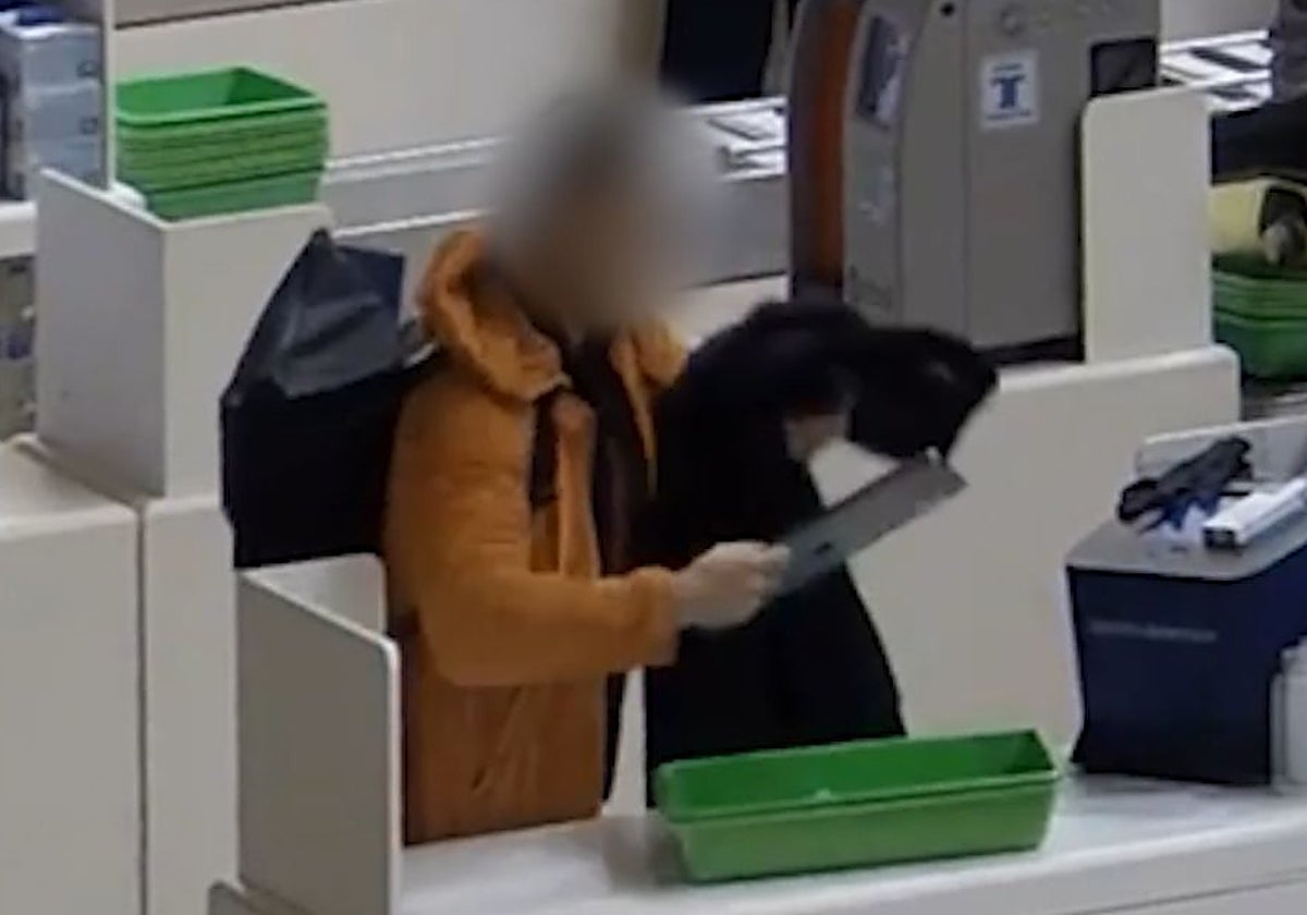 Uno de los ladrones actuando en uno de los controles de seguridad del aeropuerto de Barajas