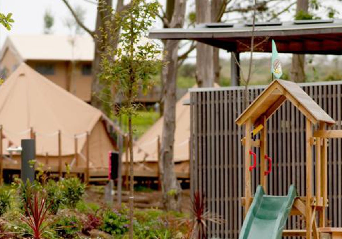 Tiendas superiores y parque infantil en la zona glamping de un cámping en Ons