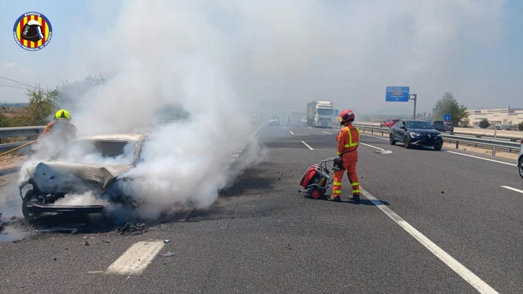 El vehículo calcinado por el fuego y el corte de carriles de la carretera, con el tráfico retenido