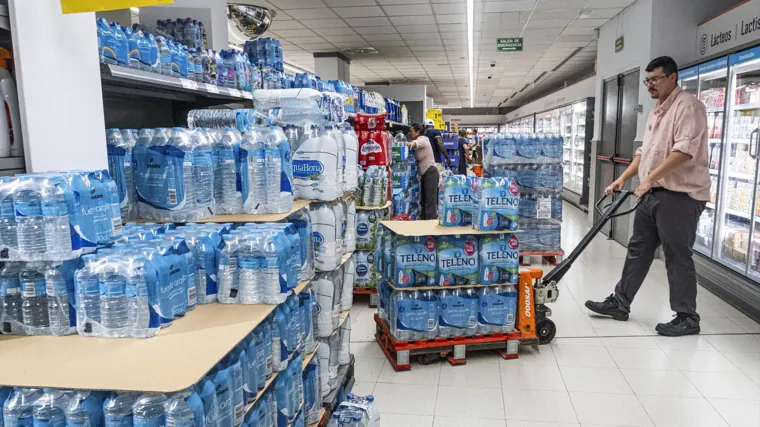 Un trabajador transporta botellas de agua en el municipio alicantino, donde el consumo se ha disparado al no ser apta para todos los usos la del grifo