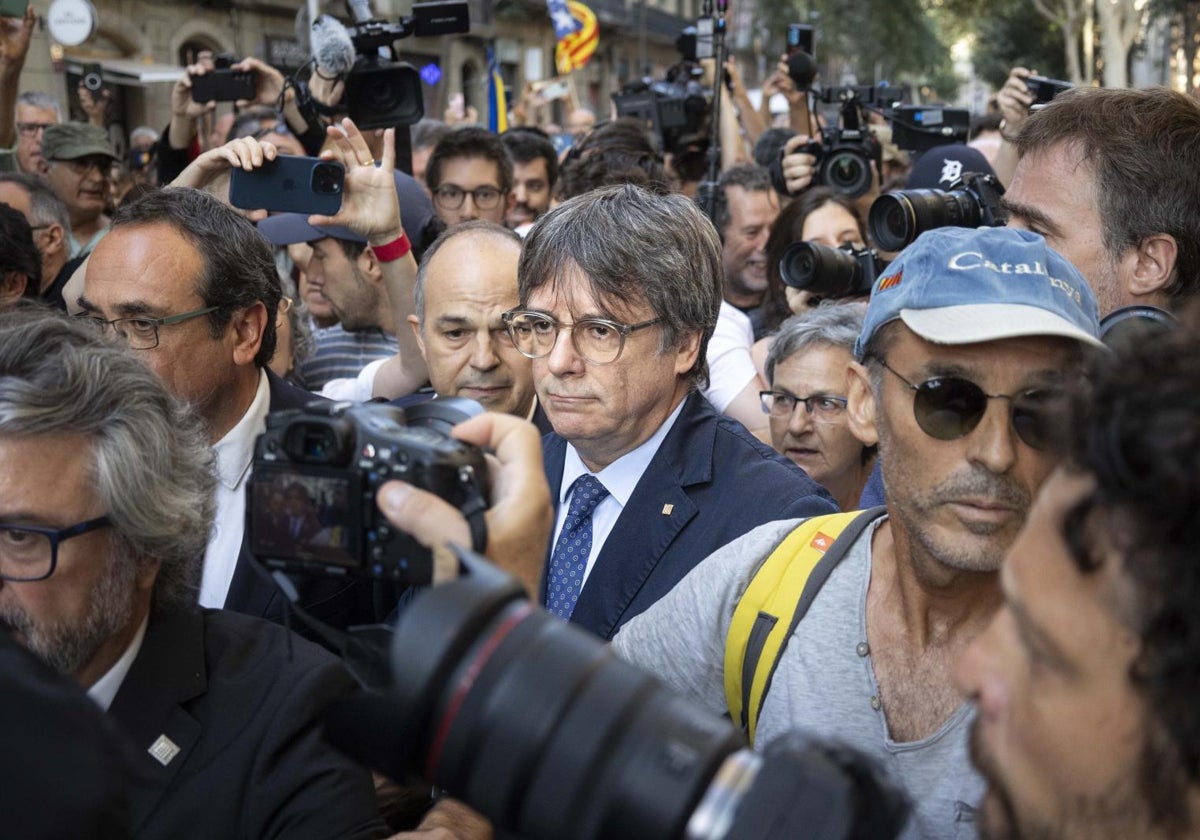 Puigdemont llega al acto; con gorra, un miembro de su seguridad