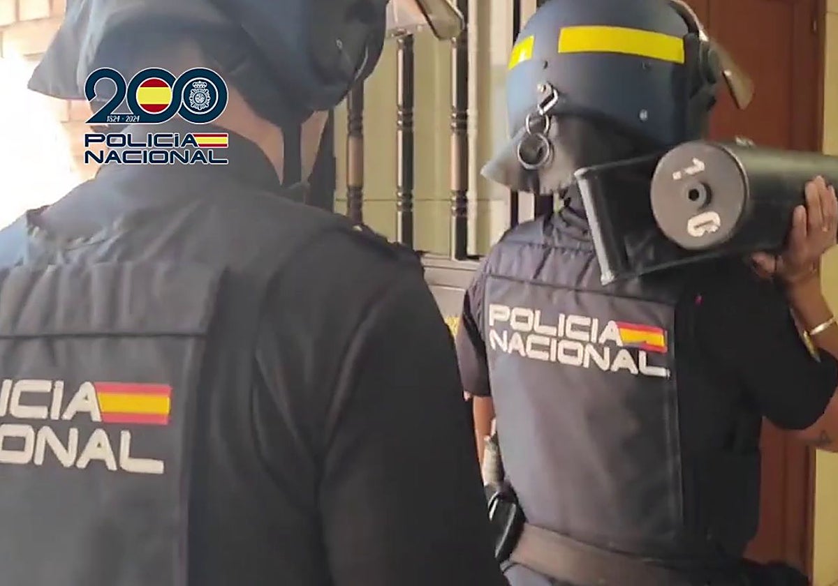 Dos agentes procediendo a entrar al domicilio del arrestado