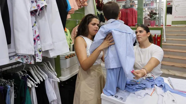 Un niño se prueva ropa para el próximo curso, este lunes en Helena Uniformes