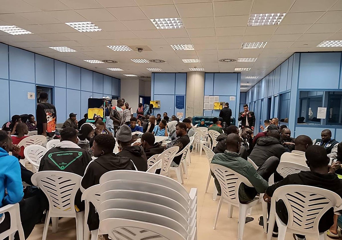 Decenas de inmigrantes esperan en una de las salas de asilo de Barajas