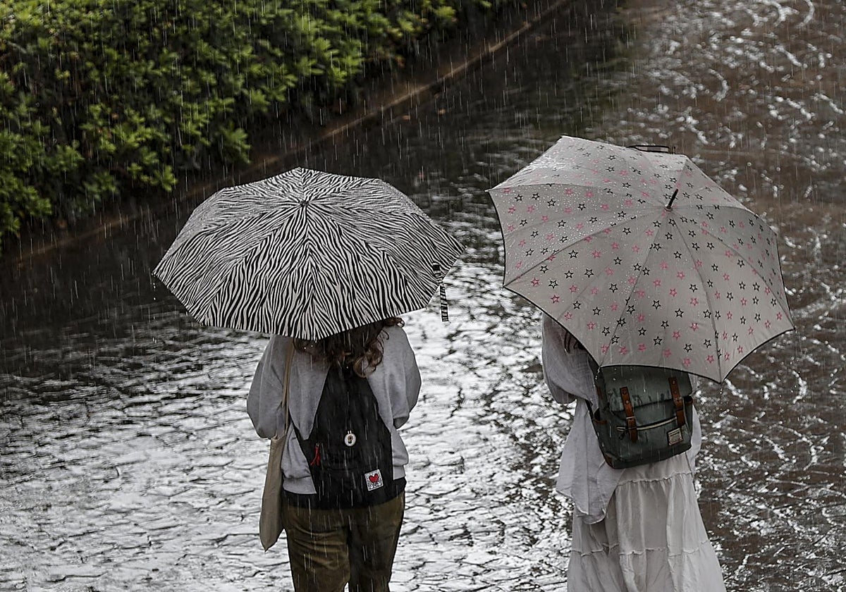 Dos transeúntes caminan bajo la lluvia en la Comunidad Valenciana