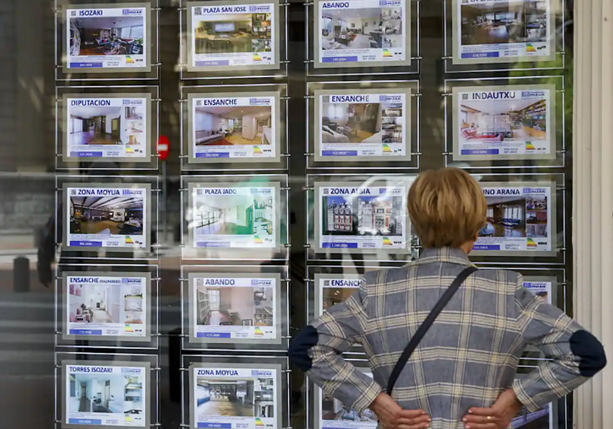 Una mujer en Bilbao frente a una inmobiliaria en foto de archivo