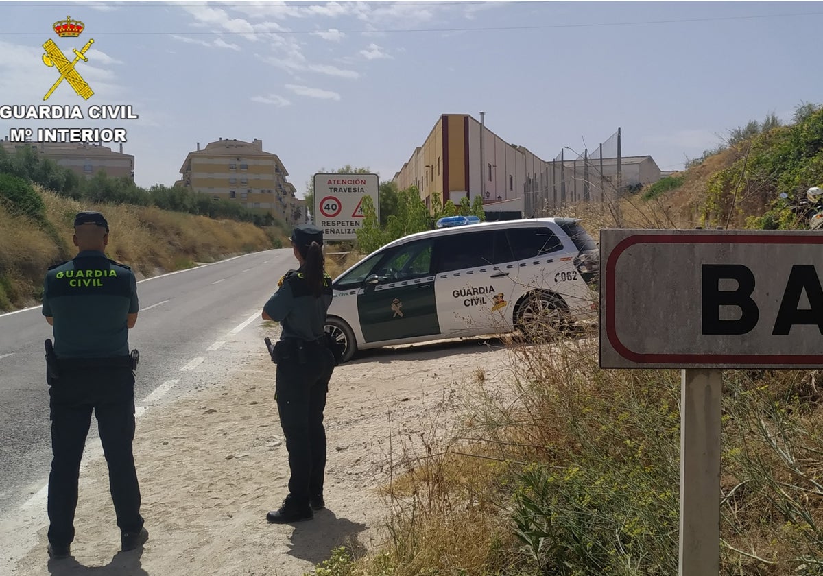 Dos agentes de la Guardia Civil vigilan un acceso a Baena