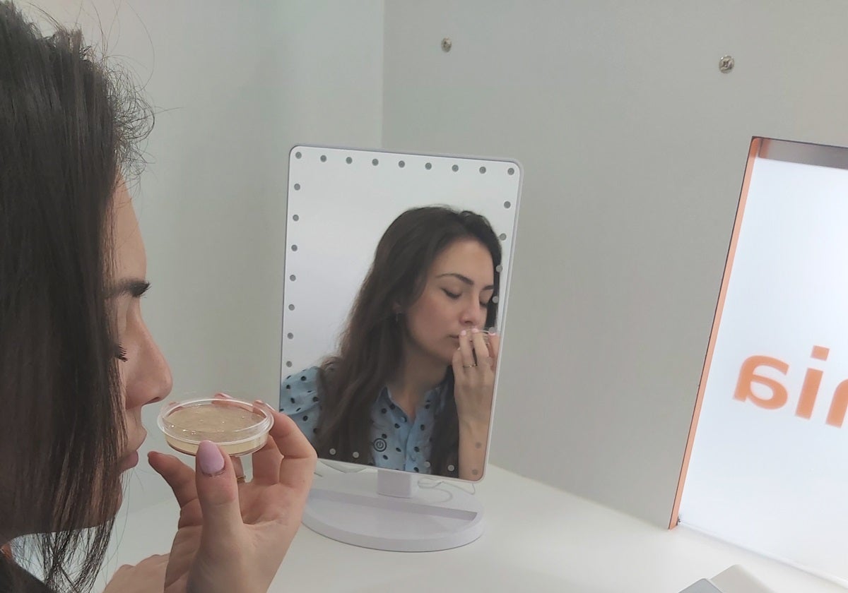 Imagen de una mujer con un producto cosmético durante un análisis de Ainia