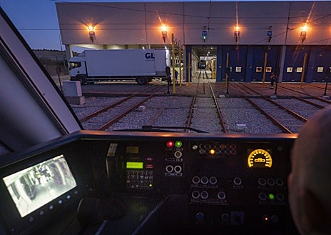 Imagen secundaria 1 - Arriba, las jaulas con los paquetes entran en el tren en la estación de El Bercial. Abajo, izquierda, desde la cabina del tren se ve el camión que le espera, preparado para la descarga. Derecha, el camión, ya con los paquetes, toma el camino hacia el almacén central de GLS
