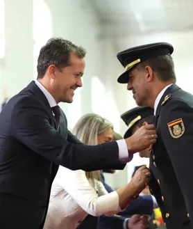 Imagen secundaria 2 - La imagen que presidió el acto; policías uniformados entre los asistentes y el alcalde de Toledo, Carlos Velázquez, condecorando a un agente 