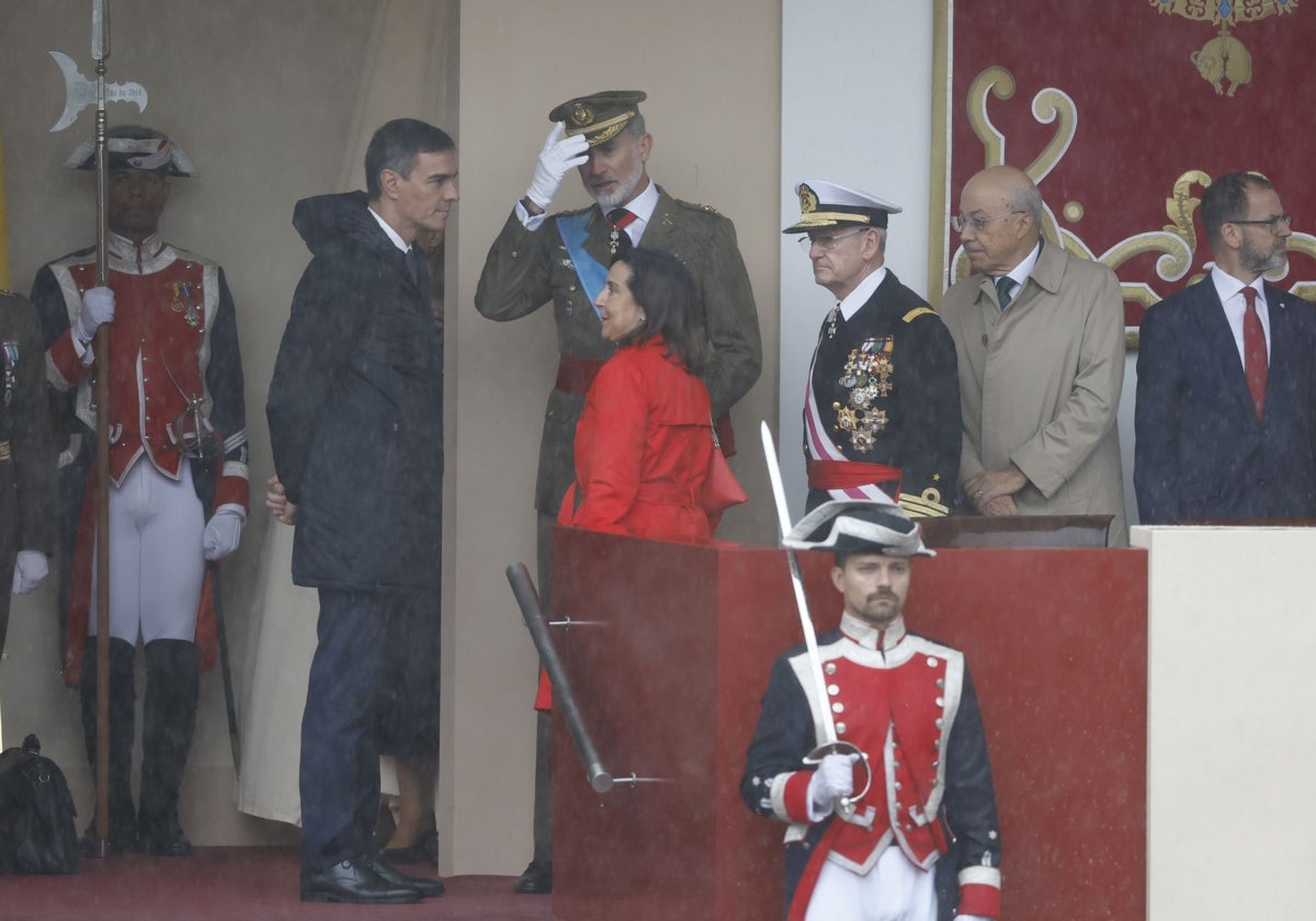 El Rey conversando con Pedro Sánchez y Margarita Robles en un momento del desfile