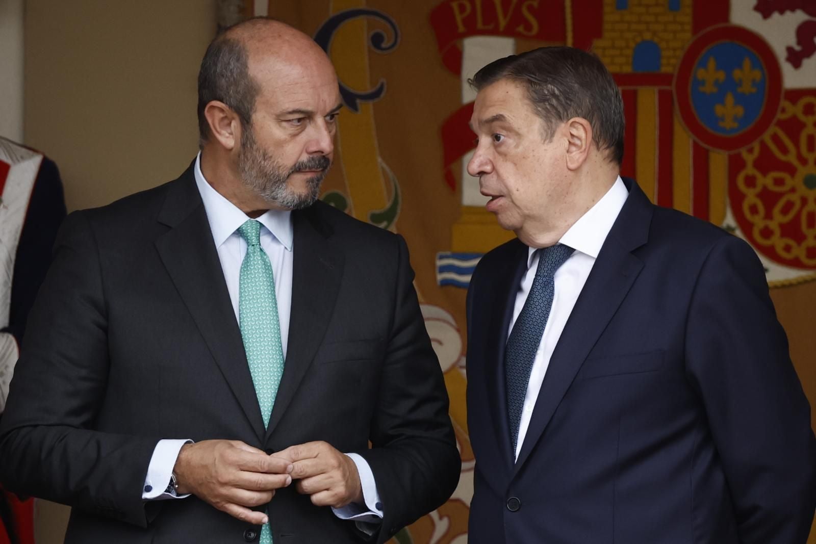 El ministro de Agricultura, Luis Planas, hablando con el presidente del Senado, Pedro Rollán, en la zona de la tribuna real